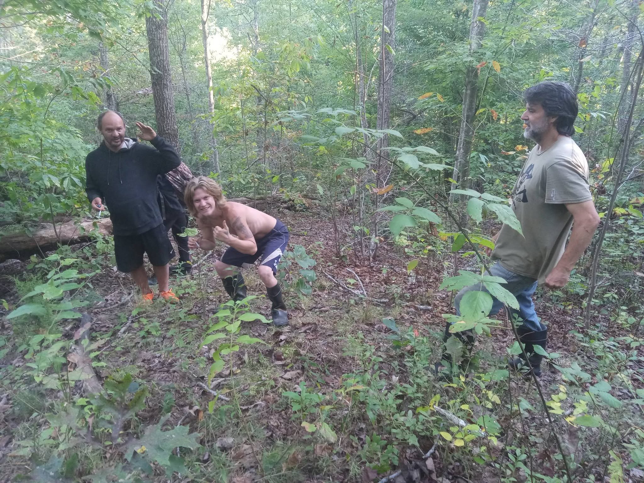 People working together in the wooded sanctuary landscape.