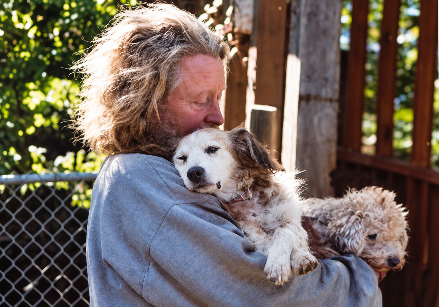 Randy Skaggs holding a rescued dog, with another dog beside him